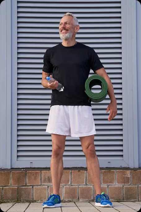 healthy older man smiling with water and foam roller