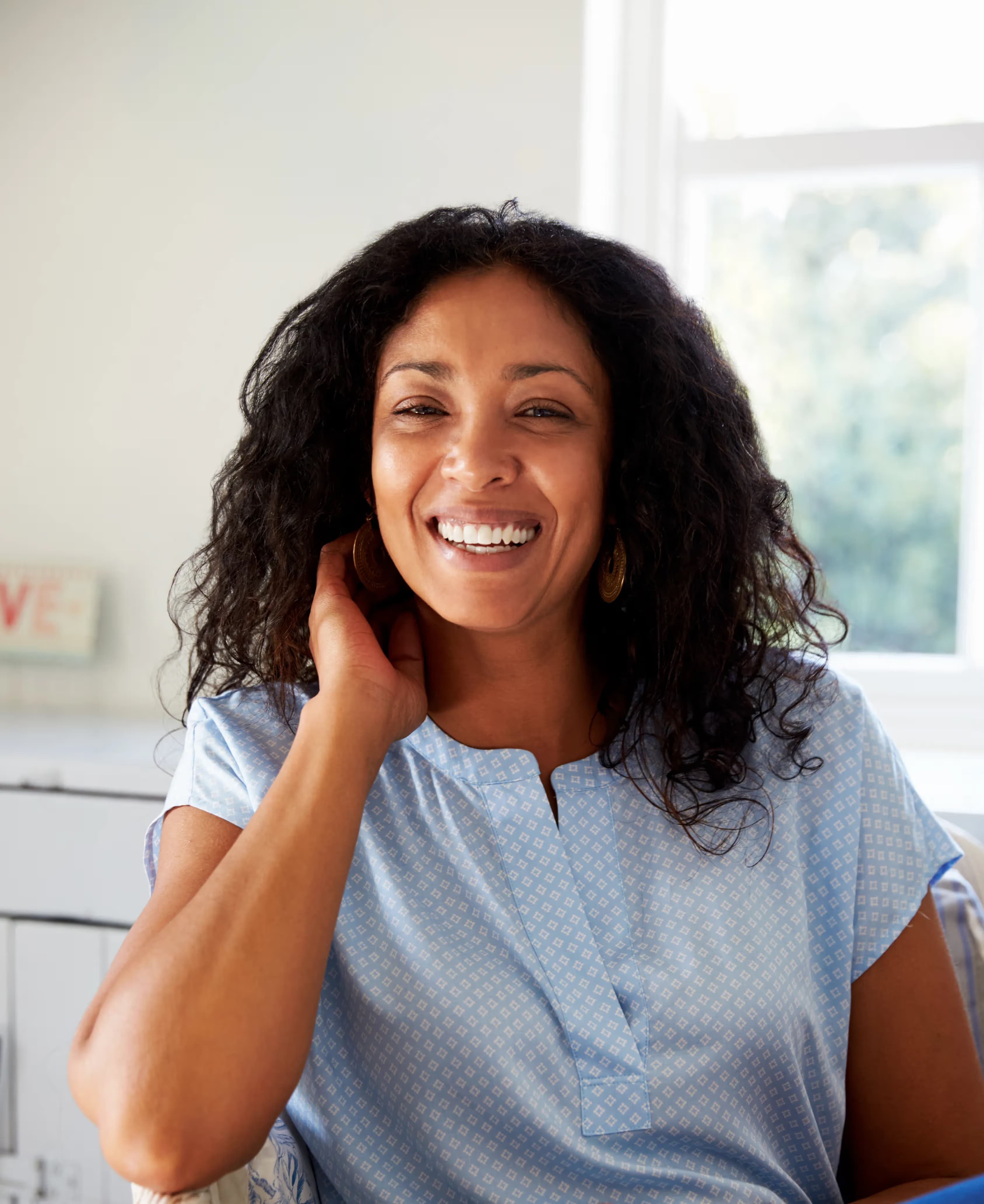 woman smiling while holding her hand to her face