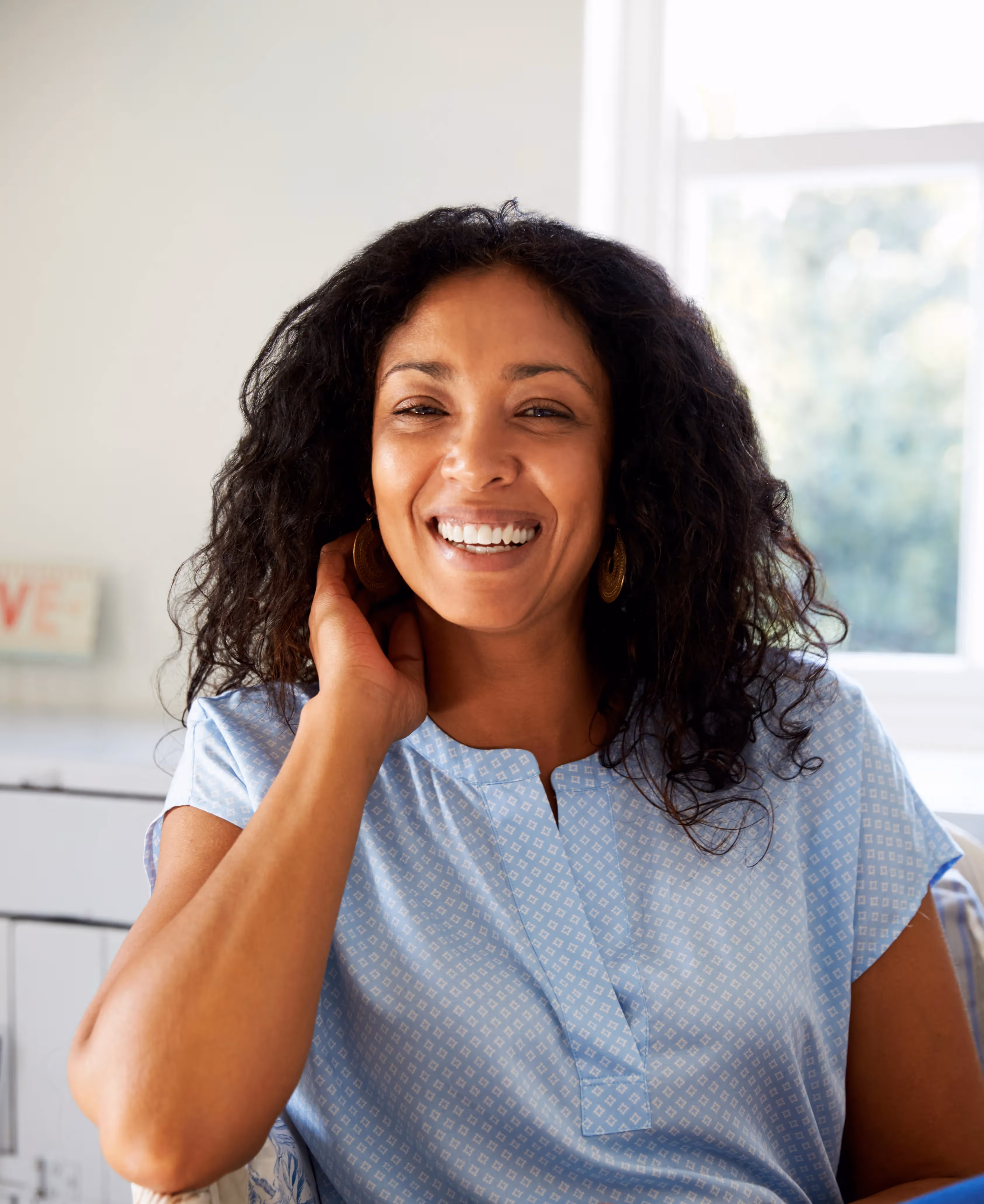 woman smiling while holding her hand to her face