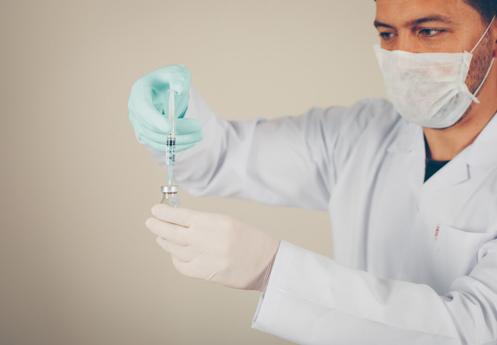 The current image has no alternative text. The file name is: side-view-doctor-with-gloves-mask-unfilling-syringe-into-vial-horizontal-scaled.jpg
